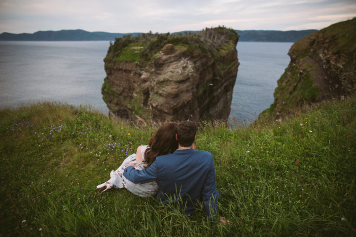 Couple relaxing in the grass during an engagement session on Bell Island Newfoundland and Labrador