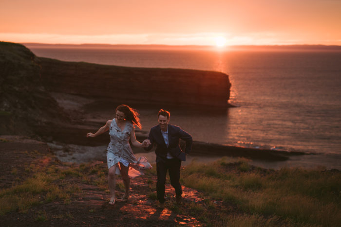 Couple running during sunset engagement session on Bell Island Newfoundland and Labrador