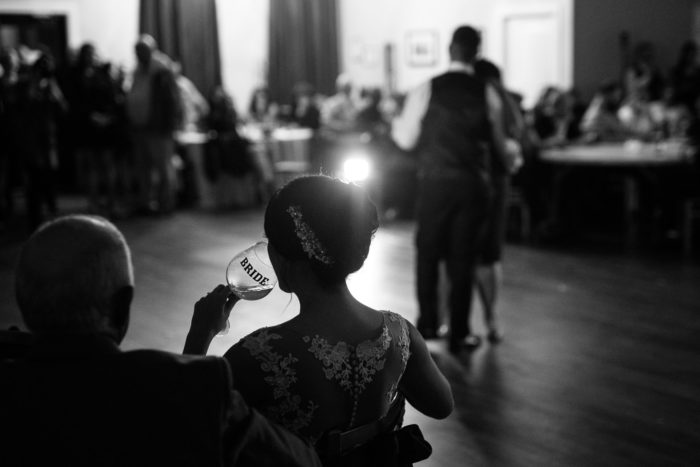 Bride sipping wine while groom dances with mother in Twillingate Newfoundland and Labrador