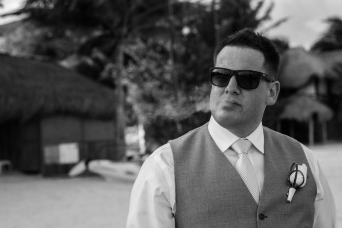 Groom Smoking cigar at secrets resort and spa destination wedding in Mexico